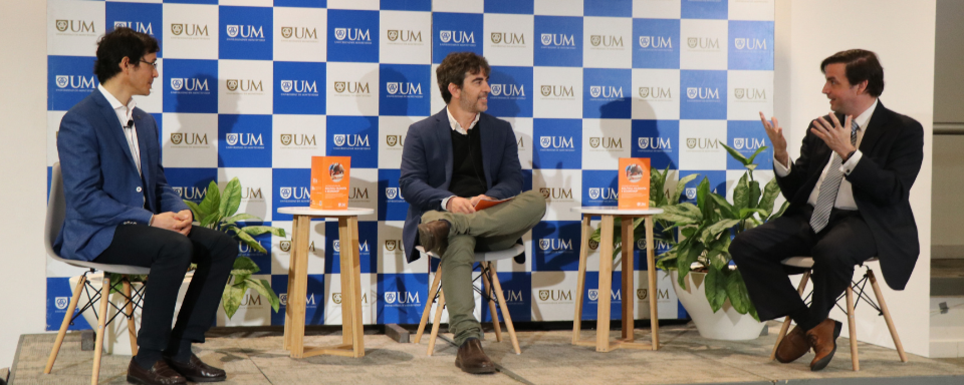 Profesores de la UM junto a moderador del encuentro durante el panel.