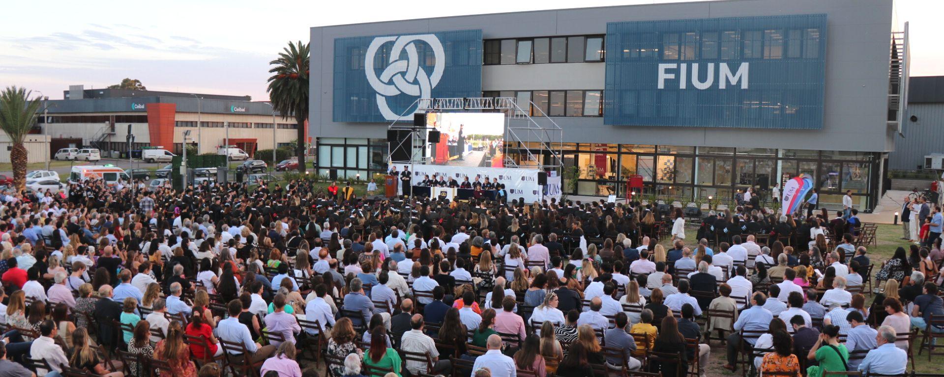 Graduación UM 7 de diciembre: público y graduados frente a escenario con autoridades tras la mesa